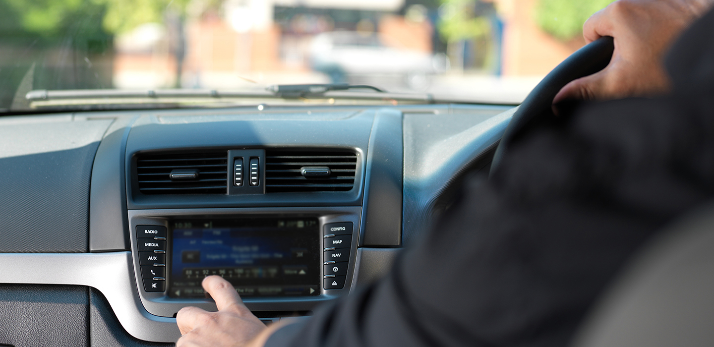 Changing the radio station in the car while driving